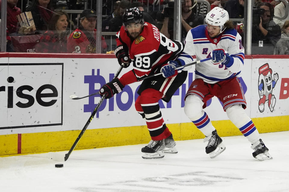 New York Rangers left wing Artemi Panarin (10) defends against Chicago Blackhawks center Andreas Athanasiou (89) during the second period of an NHL hockey game Sunday, Dec. 18, 2022, in Chicago. (AP Photo/David Banks)