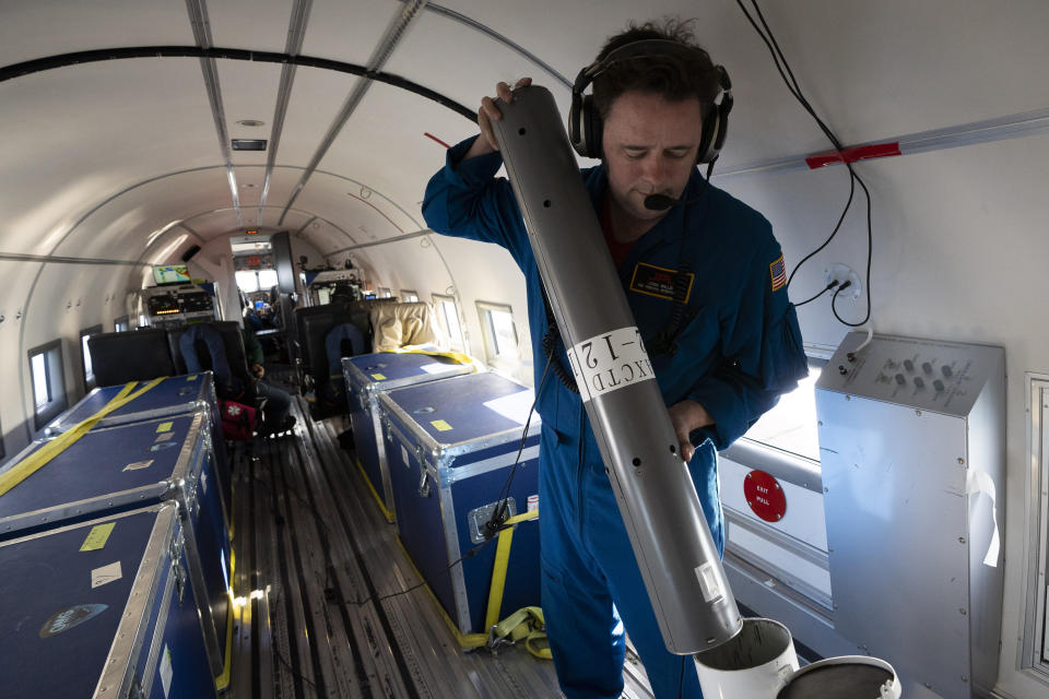 In this photo taken on Wednesday, Aug. 14, 2019, NASA scientist Josh Willis prepares to release a probe from a plane as they fly above the Kangerlussuaq Glacier in eastern Greenland. Greenland has been melting faster in the last decade and this summer, it has seen two of the biggest melts on record since 2012. (AP Photo/Mstyslav Chernov)