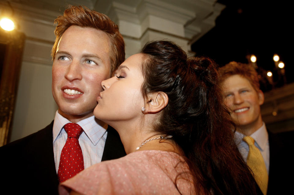 An actress kisses a wax figure of Britain's Prince William near another wax figure of Prince Harry during the statues' unveiling ceremony at the Madame Tussaud Wax Museum in Amsterdam April 26, 2007. REUTERS/Jerry Lampen