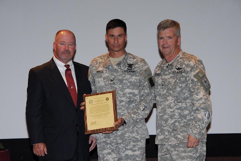 This handout photo provided by the US Army, taken in Jan. 2010, shows retired Army Col. Bert Vergez, center, receiving his charter to manage the Project Office for Non-Standard Rotary Wing Aircraft (NSRWA), established in January 2010, from the Program Executive Officer for Aviation, now Maj. Gen. William Crosby, right, and Randy Harkins, former deputy project manager NSRWA. The Justice Department is building a corruption case against a flamboyant Wall Street financier who won millions of dollars in military contracts and then hired the Army officer who steered the money her way. Interviews and documents obtained by The Associated Press portray entrepreneur Lynn Tilton and Col. Bert Vergez as being in unusually close contact for more than a year before Vergez retired from the Army in late 2012. Among the allegations is that Vergez provided Tilton with details about upcoming contracts to give her company, MD Helicopters of Mesa, Ariz., an advantage over the competition. (AP Photo/US Army)