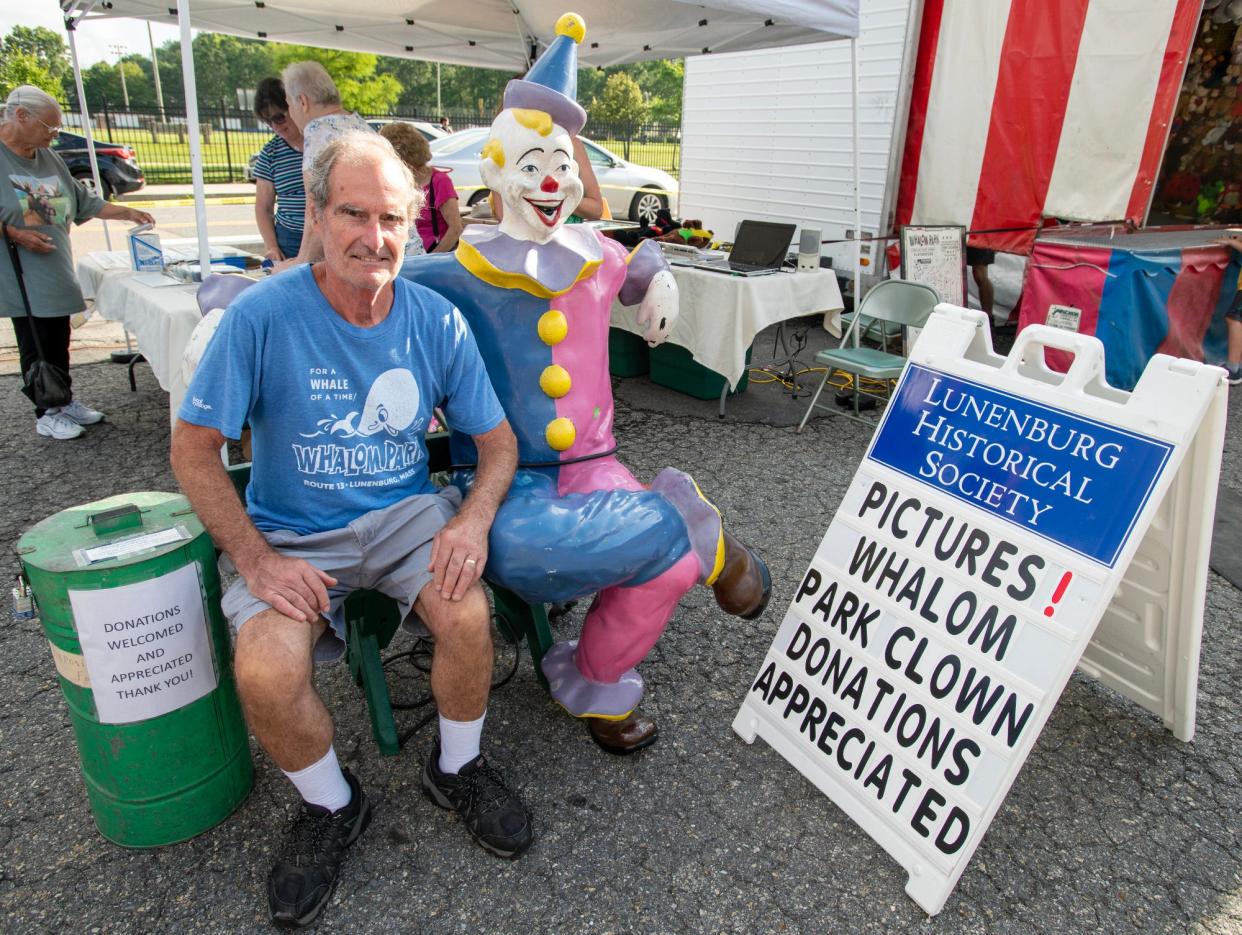 Bill Tyler sits with a clown statue saved from Whalom Park at the Whalom Weekend carnival Friday. Tyler is the curator of the Lunenburg Historical Society and has a collection of items from the former amusement park.