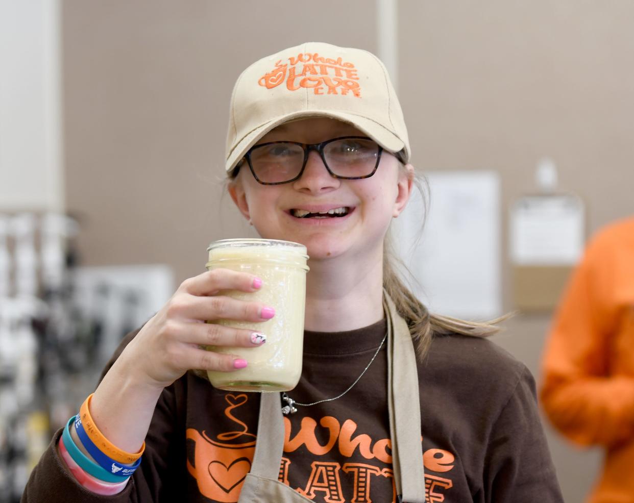 Caroline Humbert displays a beverage at Whole Latte Love Cafe in North Canton. She's the daughter of Beth Humbert, founder of Whole Latte Love Cafe, which provides a workplace for young adults with disabilities.