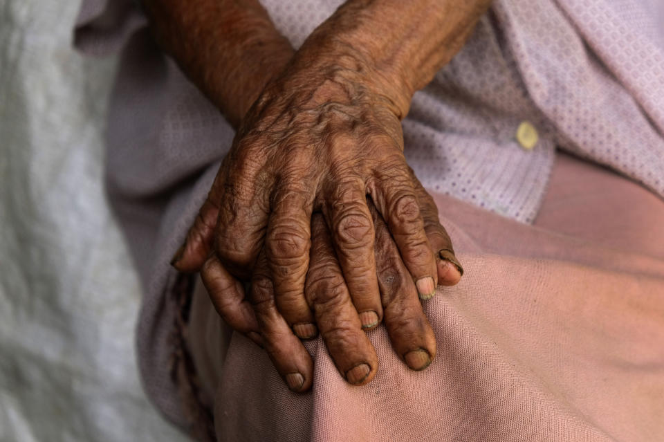 Kuozeu Vizo, a 98-year-old Angami Naga woman, clasps her hands together as she speaks about memories of the bloody battle between the Japanese and British Commonwealth forces that took place in her village during the World War II, in Kohima, India, Friday, Aug. 14, 2020. To Vizo, the sight of her village bombed and burned black was as spellbinding as a rice field, golden and ripe for harvest. "I still wonder how they even knew which land belonged to whom when they started rebuilding the village," Vizo said. (AP Photo/Yirmiyan Arthur)