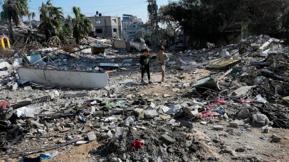 PHOTO: Palestinians walk through destruction from the Israeli bombardment in the Nusseirat refugee camp in Gaza Strip, Jan. 19, 2024.  (Adel Hana/AP)