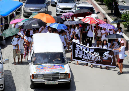 Relatives and loved ones of Leover Miranda, 39, a drug-related killings victim, hold a streamer calling to stop the continuing rise of killings due to the President Rodrigo Duterte's ruthless war on drugs, during a funeral march at the north cemetery in metro Manila, Philippines August 20, 2017. REUTERS/Romeo Ranoco
