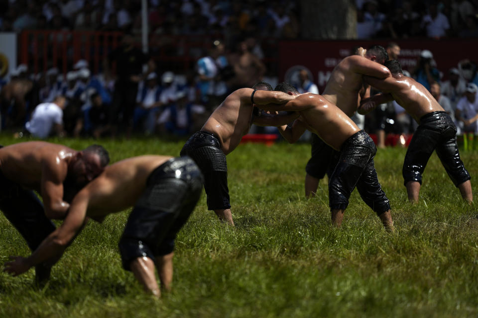Wrestlers compete during the 663rd annual Historic Kirkpinar Oil Wrestling championship, in Edirne, northwestern Turkey, Saturday, July 6, 2024. Wrestlers take part in this "sudden death"-style traditional competition wearing only a pair of leather trousers and a good slick of olive oil. The festival is part of UNESCO's List of Intangible Cultural Heritages. (AP Photo/Khalil Hamra)