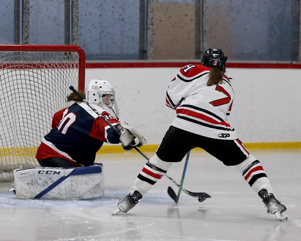 Pembroke goalie Emily LaVallee pokes the puck away from Hingham’s Caroline Doherty to prevent a goal scoring opportunity during third period action of their game against Hingham at Pilgrim Arena on Saturday, Feb. 18, 2023.