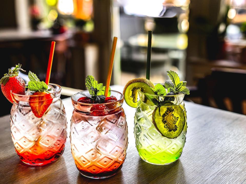 three fruity drinks in a line on a table