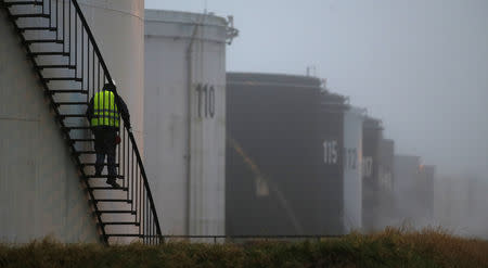 FILE PHOTO - A worker walks down the stairs of an oil tank at the Total refinery in Grandpuits, near Paris, January 6, 2015. REUTERS/Christian Hartmann