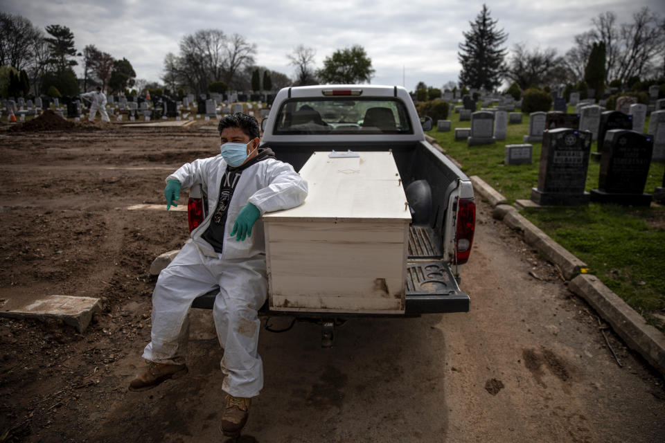 Gravedigger Thomas Cortez accompanies a casket as it's brought to the plot for burial at Hebrew Free Burial Association's Mount Richmond Cemetery in the Staten Island borough of New York, Wednesday April 8, 2020. The group serves Jews who mostly die with little or nothing. A century ago, it buried garment workers killed in the Triangle Shirtwaist fire and those who fell to the Spanish flu. More recently, it was Holocaust survivors who fled Europe. And now, those dying of the coronavirus. (AP Photo/David Goldman)