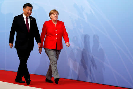 FILE PHOTO: Chinese President Xi Jinping walks next to German Chancellor Angela Merkel to attend the G20 leaders summit in Hamburg, Germany July 7, 2017. REUTERS/Wolfgang Rattay/File Photo