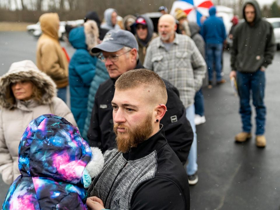 Neil Figley, 28, holds his daughter, Harlie, 4, wait in line at the Norfolk Southern Assistance Center to collect a $1000 check and get reimbursed for expenses while they were evacuated following a train derailment prompting health concerns on February 17, 2023 in East Palenstine, Ohio. On February 3rd, a Norfolk Southern Railways train carrying toxic chemicals derailed causing an environmental disaster. Thousands of residents were ordered to evacuate after the area was placed under a state of emergency and temporary evacuation orders.