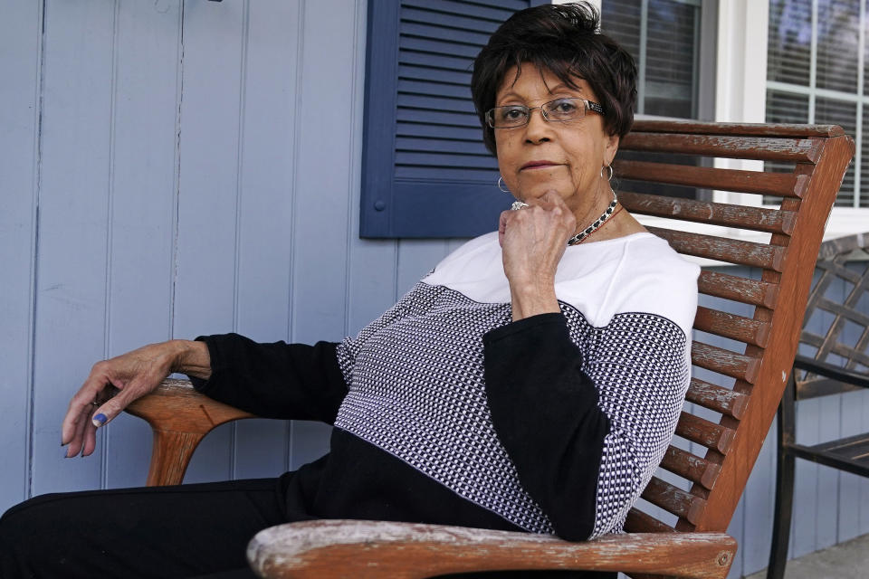 Roberta Wolff, a descendant of Tony, Cuba and Darby Vassall who were enslaved by Harvard benefactors in the institution's first decades, poses on the front porch of her family home, Wednesday, April 27, 2022, in Bellingham, Mass. In Harvard's pledge to atone for its ties to slavery, it identified dozens of people who were enslaved by the university's first leaders and faculty members. Hundreds of years later, their living descendants are estimated to number in the thousands, including some who lived and worked in the Boston area without knowing their family connection to the Ivy League school. (AP Photo/Charles Krupa)