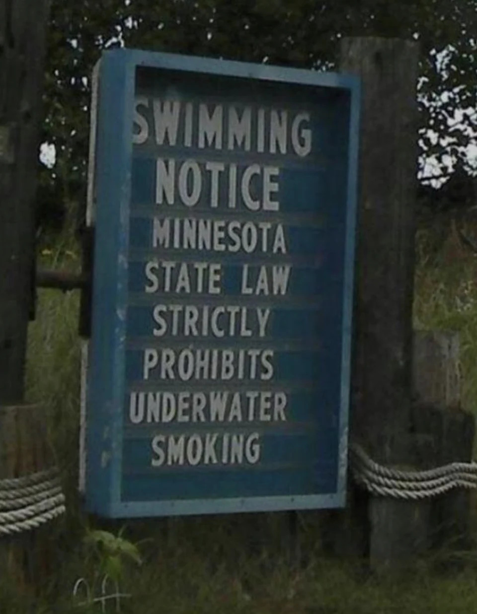 Sign reads "Swimming Notice: Minnesota State Law strictly prohibits underwater smoking."