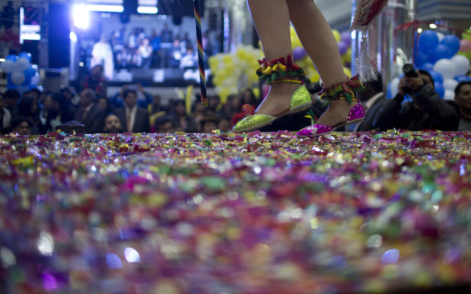 A contestant competes on stage blanketed in confetti in the Queen of Great Power contest, in La Paz, Bolivia, Friday, May 24, 2019. The largest religious festival in the Andes choses its queen in a tight contest to head the Festival of the Lord Jesus of the Great Power, mobilizing thousands of dancers and more than 4,000 musicians into the streets of La Paz. (AP Photo/Juan Karita)