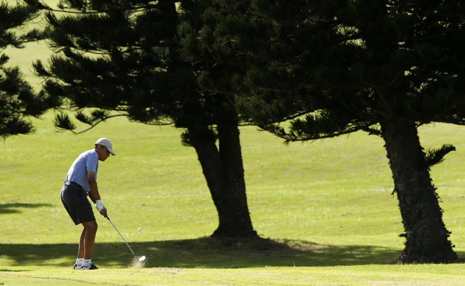 U.S. President Barack Obama hits toward the 18th green during a round of golf at Mid Pacific Country Club in Kailua, Hawaii December 23, 2013. REUTERS/Kevin Lamarque (UNITED STATES - Tags: POLITICS SPORT GOLF)