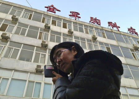 Wang Yu, the lawyer of human right activist Cao Shunli, talks on the phone in front of a hospital building where Cao is hospitalized at its intensive care unit in Beijing in this March 1, 2014 file photo, after she was not allowed to see Cao. REUTERS/Kim Kyung-Hoon/Files