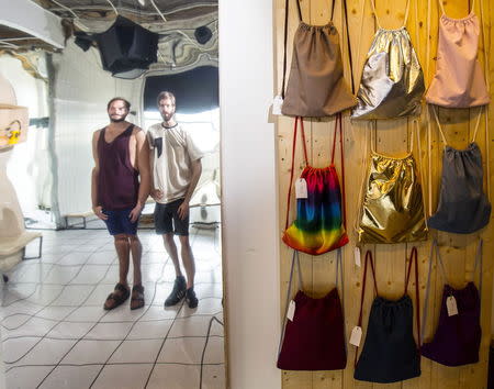 The director and actor at copy & waste Steffen Klewar (R) and actor Daniel Brunet are refelcted on a distrorted mirror at the concept store "Knick-Knack to the Future" in Berlin, Germany, September 1, 2015. REUTERS/Hannibal Hanschke