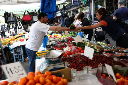 A woman buys produce at a market stall in London, Britain May 16, 2017. REUTERS/Neil Hall