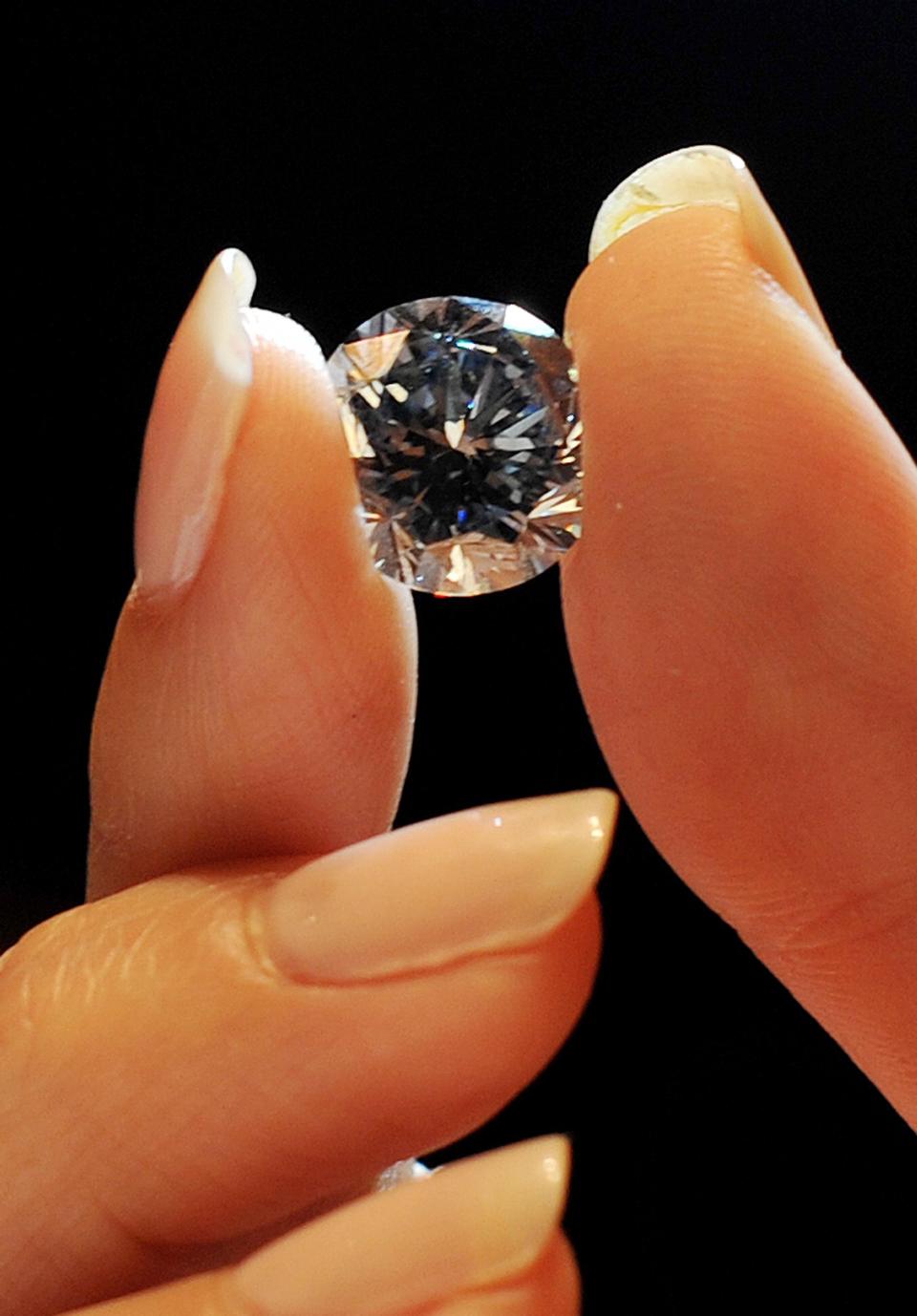 A Sotheby's employee holds the world's largest round fancy vivid blue diamond, a 7.59 Carat stone, estimated in excess of 12 million at Sotheby's,central London, during a preview of Sotheby's forthcoming London Rocks sale in October, when two diamonds, the white diamond at 118.28 carats, the largest D colour Flawless diamond, estimated between 18-22 million and round fancy vivid blue diamond are expected to fetch over 30 million between them at the sale.