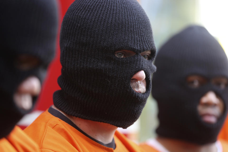 A British national, center, detained on drugs charges is displayed during a news conference in Bali, Indonesia on Friday, Aug. 5, 2022. Authorities in Indonesia arrested three foreigners, for distributing cocaine on the Indonesian resort island of Bali at the end of July. From the three suspects that are identified as British, Brazilian and Mexican, the officers from the National Narcotics Agency seized 844.59 gram (1.86 pounds) of cocaine with other drugs, including MDMA and marijuana. (AP Photo/Firdia Lisnawati)