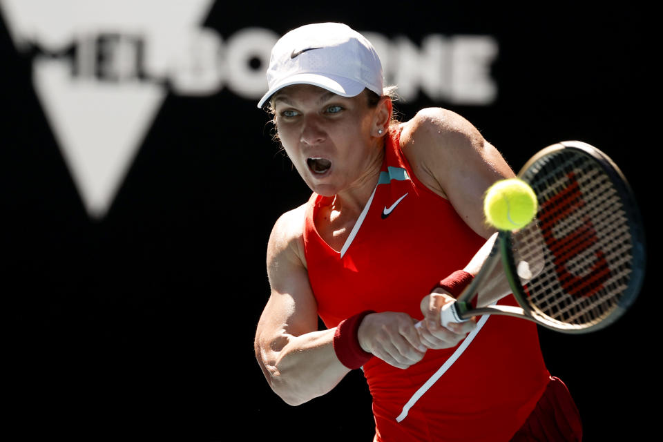 Simona Halep of Romania makes a backhand return to Alize Cornet of France during their fourth round match at the Australian Open tennis championships in Melbourne, Australia, Monday, Jan. 24, 2022. (AP Photo/Tertius Pickard)