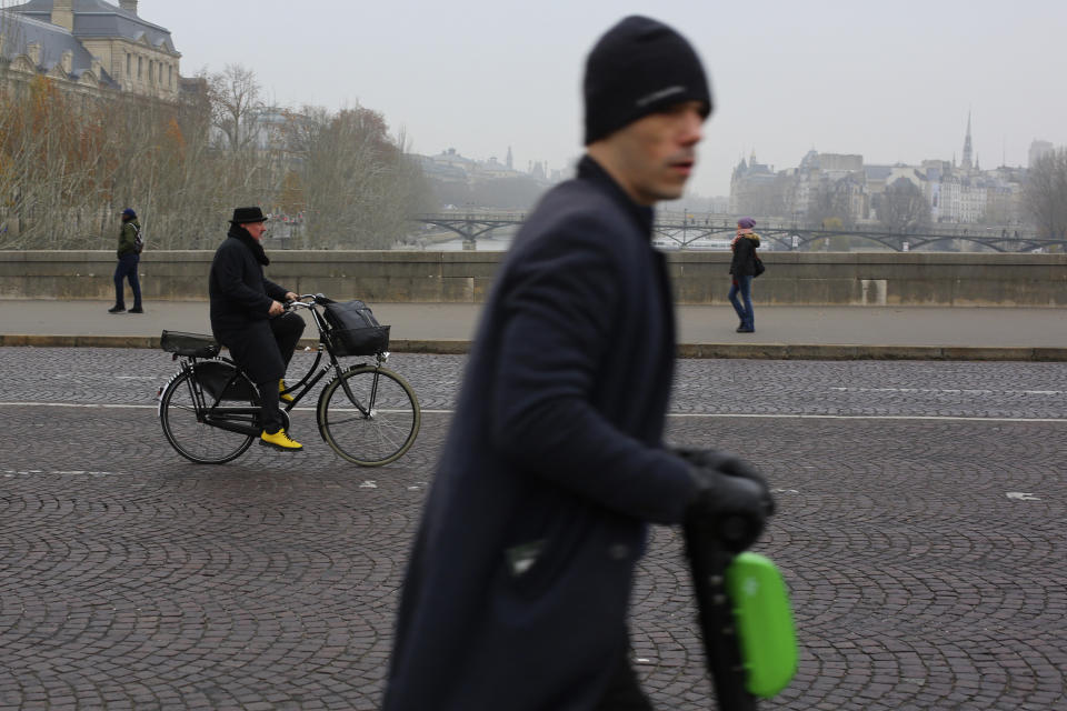 A man rides a scooter on a bridge of Paris, Thursday, Dec. 5, 2019. The Eiffel Tower shut down Thursday, France's vaunted high-speed trains stood still and teachers walked off the job as unions launched nationwide strikes and protests over the government's plan to overhaul the retirement system. (AP Photo/Rafael Yaghobzadeh)