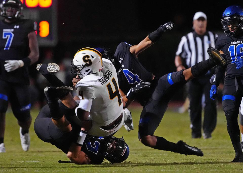 Chandler linebacker Nathan Escandon (42) and safety Kennedy Urlacher (4) make a tackle on Saguaro quarterback Devon Dampier (4) during a game at Chandler High School on Sept. 23, 2022.