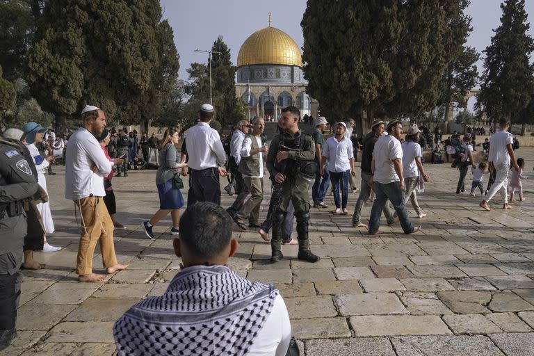 Policías israelíes escoltan a visitantes judíos en que celebran la Pascua judía en el complejo de la Mezquita de Al Aqsa, conocido por los musulmanes como Noble Santuario y por los judíos como Monte del Templo, en el casco antiguo de Jerusalén, durante el mes sagrado del Ramadán, el domingo 9 de abril de 2023. (AP Foto/Mahmoud Illean)