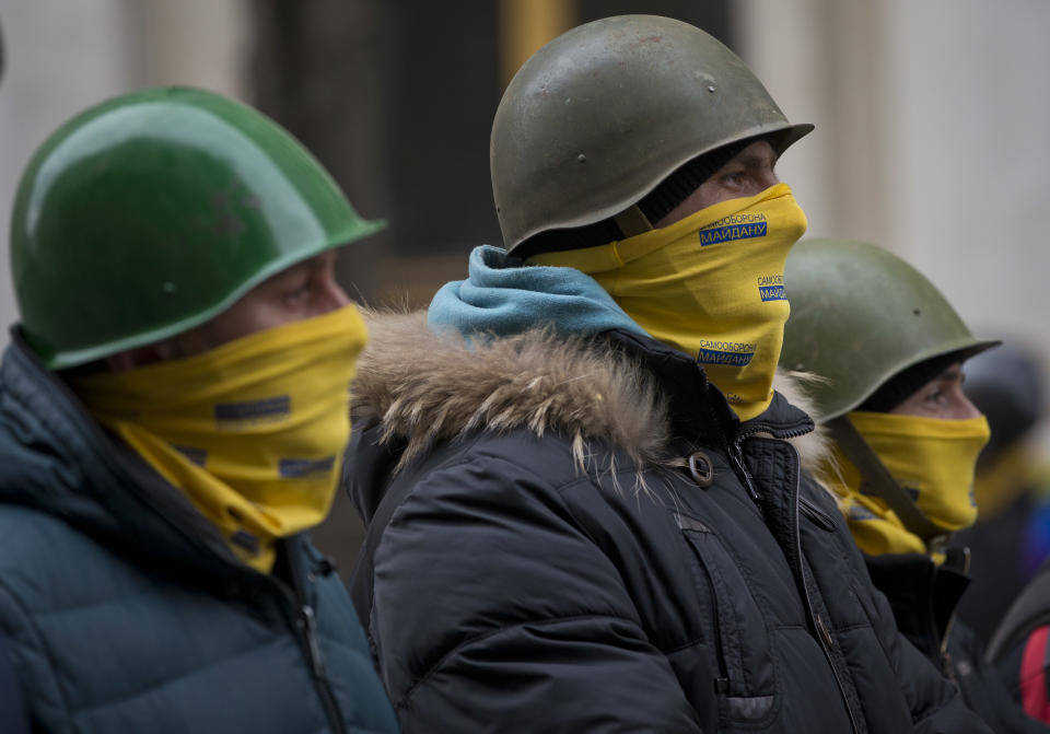 Protesters stand guard in front of presidential administrative building in central Kiev, Ukraine, Saturday, Feb. 22, 2014. Protesters in the Ukrainian capital claimed full control of the city Saturday following the signing of a Western-brokered peace deal aimed at ending the nation's three-month political crisis. The nation's embattled president, Viktor Yanukovych, reportedly had fled the capital for his support base in Ukraine's Russia-leaning east. (AP Photo/Darko Bandic)