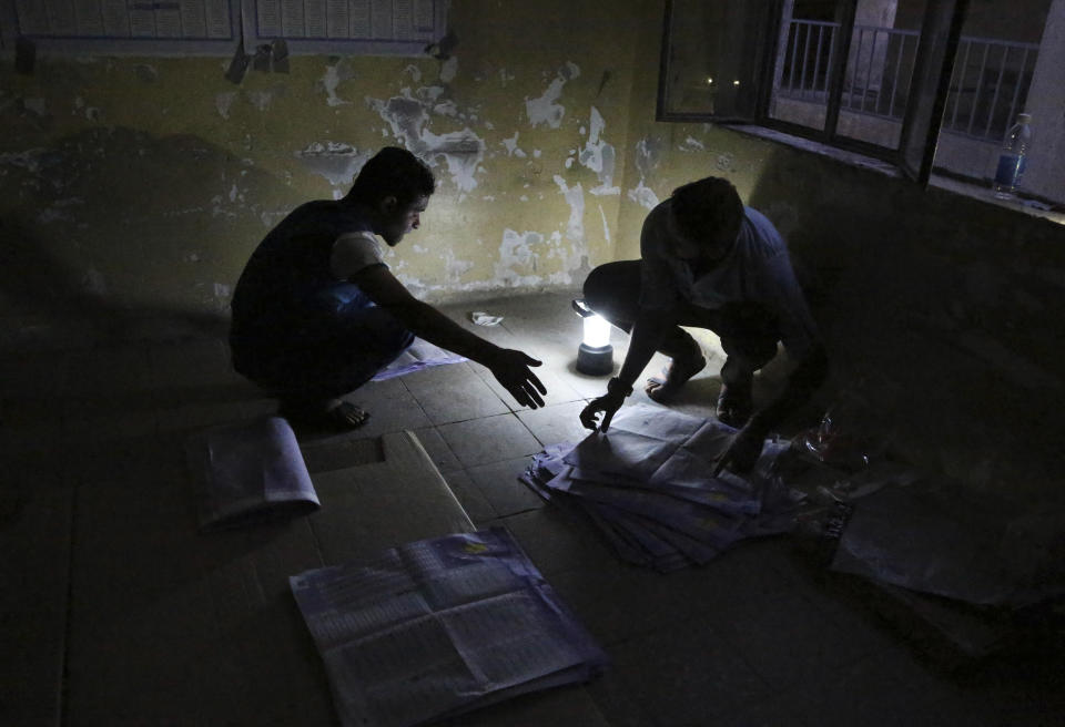 Electoral workers count ballots under lamplight, due to a power cut, as polls close at a polling center in Baghdad, Iraq, Wednesday, April 30, 2014. Iraqis braved the threat of bombs and other violence to vote Wednesday in parliamentary elections amid a massive security operation as the country slides deeper into sectarian strife. (AP Photo/Karim Kadim)