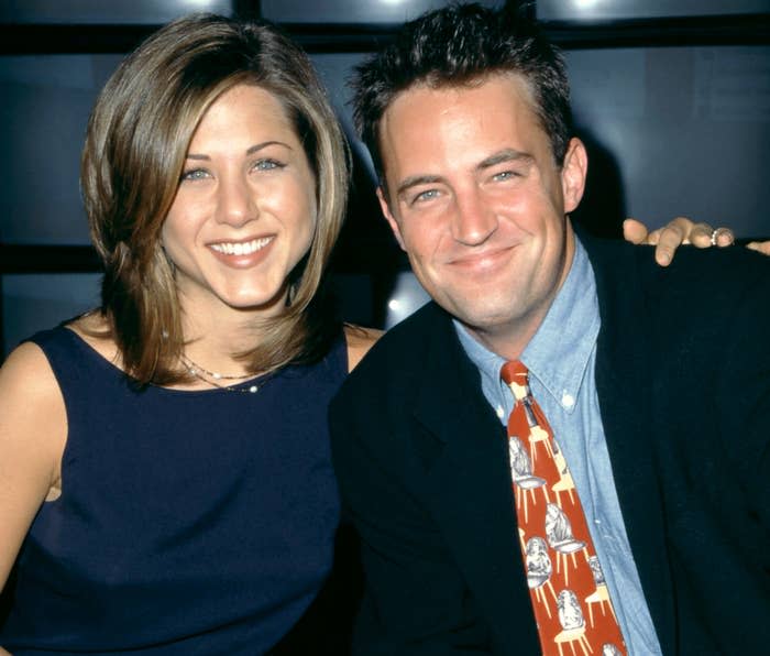 Jennifer and Matthew smile while posing during the '90s