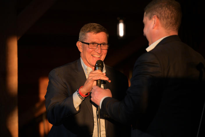 Lt. Gen. Michael Flynn, smiling, takes the microphone from U.S. Senate candidate Josh Mandel.