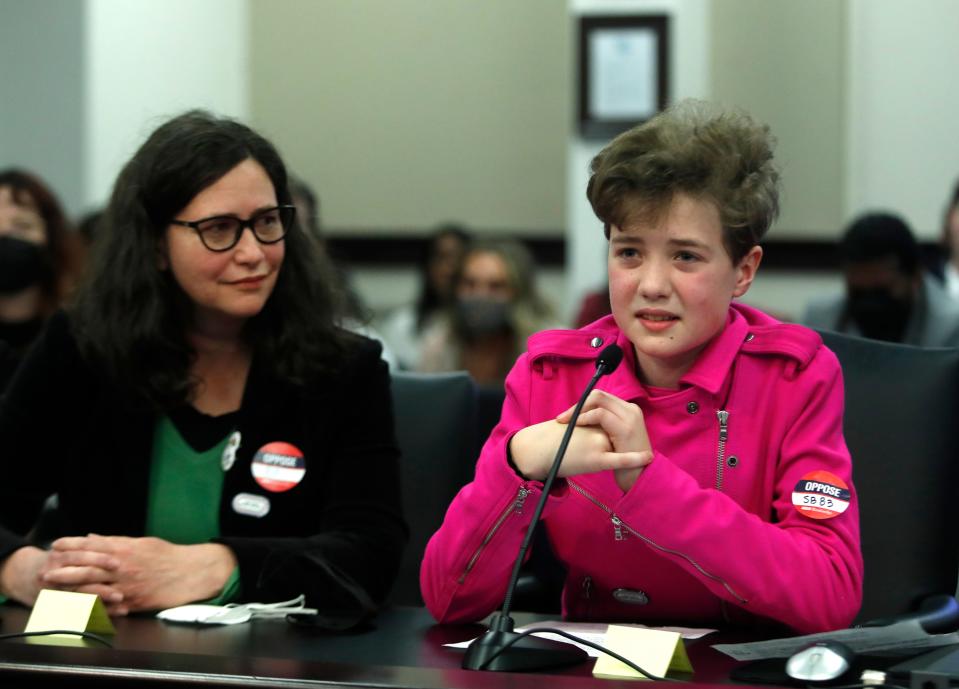 Fischer Wells testifies, while he mom Jenifer Alonzo listens, against the bill that prohibits transgender girls from playing sports on girls' teams. Feb. 10, 2022