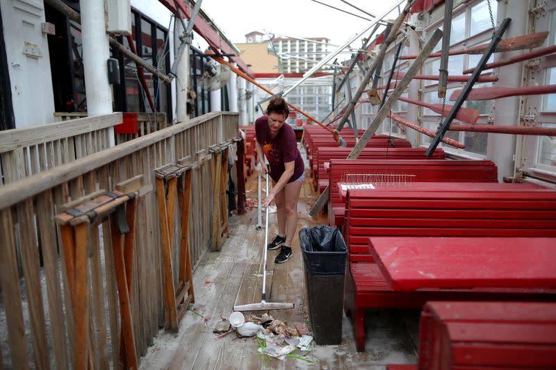FILE PHOTO: Vanessa Levan, a server at Crabs sweeps debris after Hurricane Sally in Pensacola Beach, Florida