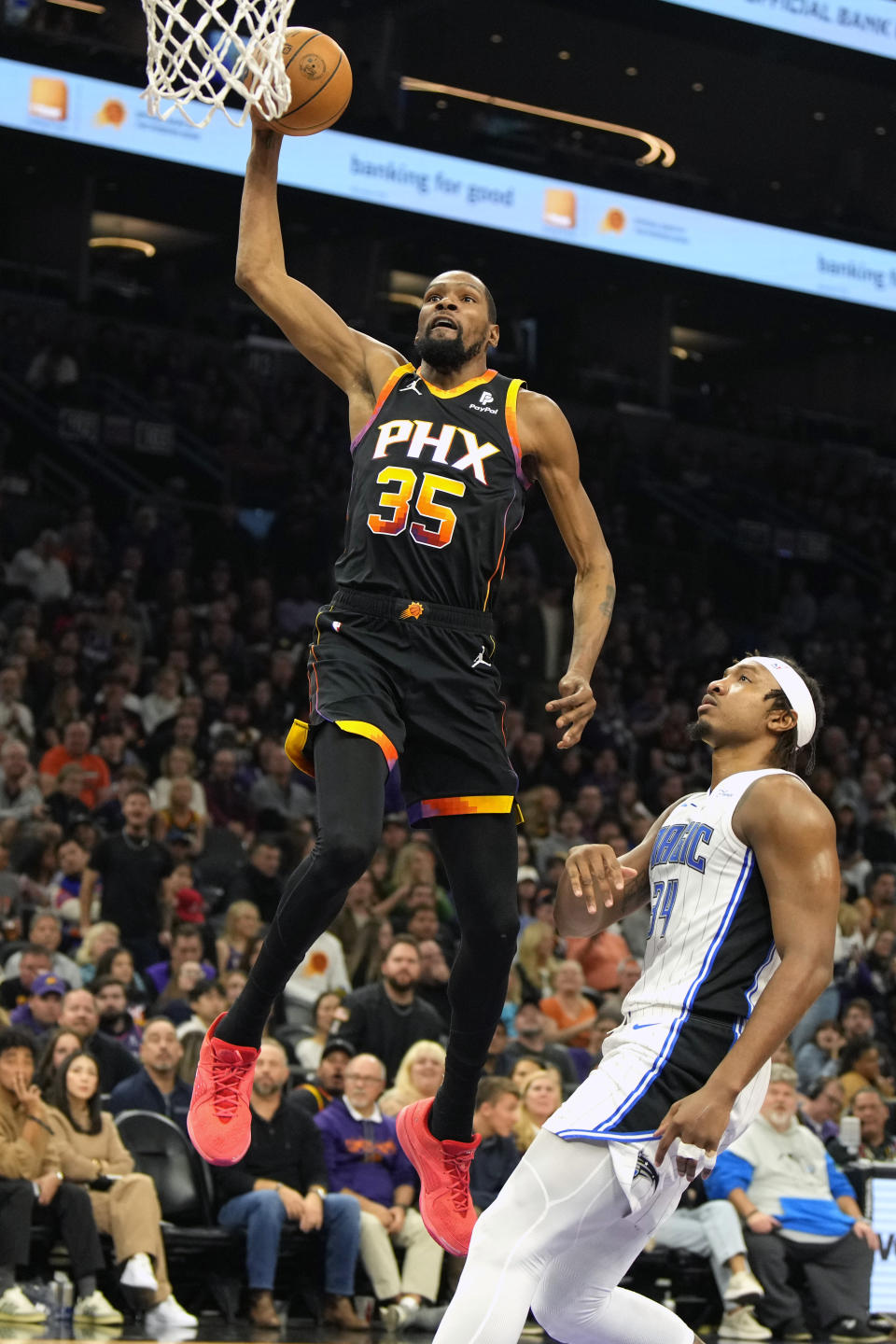Phoenix Suns forward Kevin Durant (35) dunks over Orlando Magic center Wendell Carter Jr. during the first half of an NBA basketball game, Sunday, Dec. 31, 2023, in Phoenix. (AP Photo/Rick Scuteri)