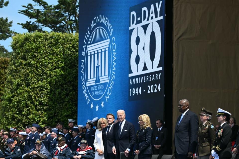 Joe Biden, Jill Biden, Emmanual Macron and Brigitte Macron stand on stage. 