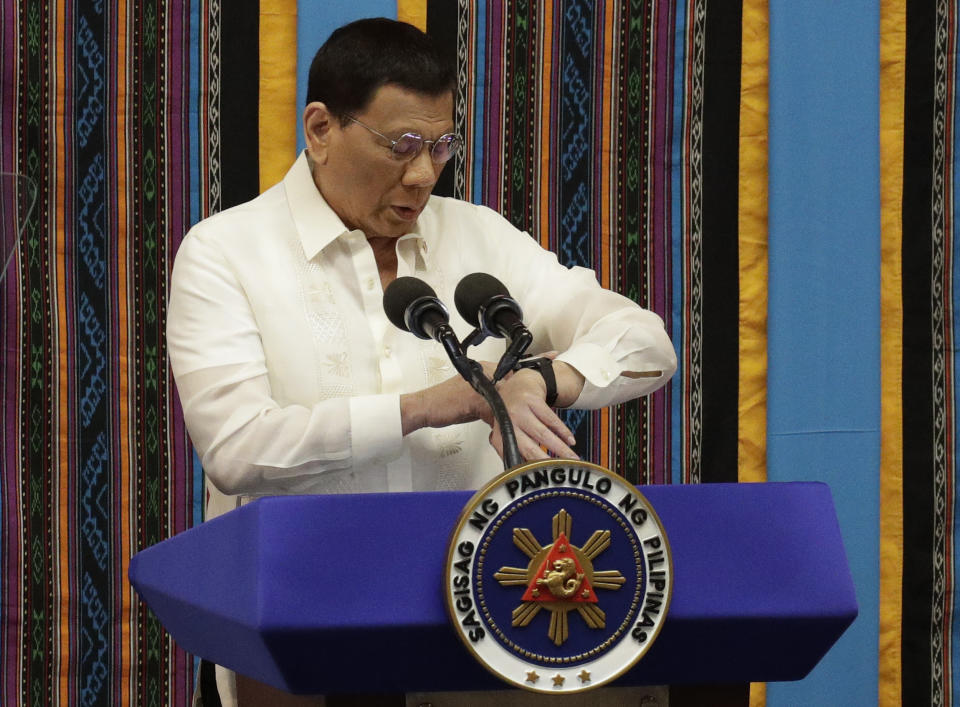 Philippine President Rodrigo Duterte looks at his watch during his 4th State of the Nation Address at the House of Representatives in Quezon city, metropolitan Manila, Philippines Monday July 22, 2019. (AP Photo/Aaron Favila)