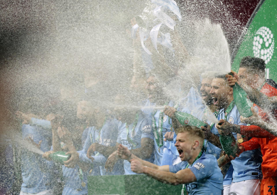 Manchester City players celebrate with the trophy after winning the English League Cup Final soccer match between Chelsea and Manchester City at Wembley stadium in London, England, Sunday, Feb. 24, 2019. (AP Photo/Tim Ireland)