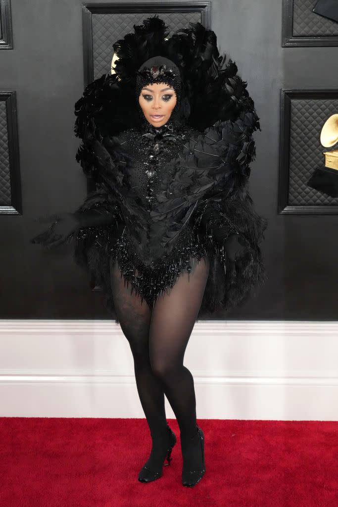 Blac Chyna in all black feathered bodice and headdress with black tights.