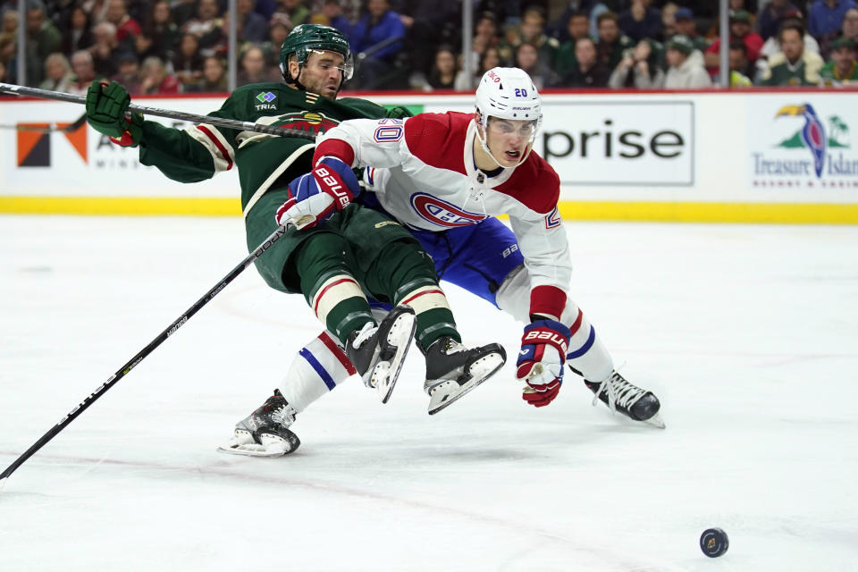 Minnesota Wild center Steven Fogarty (28) and Montreal Canadiens left wing Juraj Slafkovsky (20) collide while following the puck during the second period of an NHL hockey game Tuesday, Nov. 1, 2022, in St. Paul, Minn. (AP Photo/Abbie Parr)