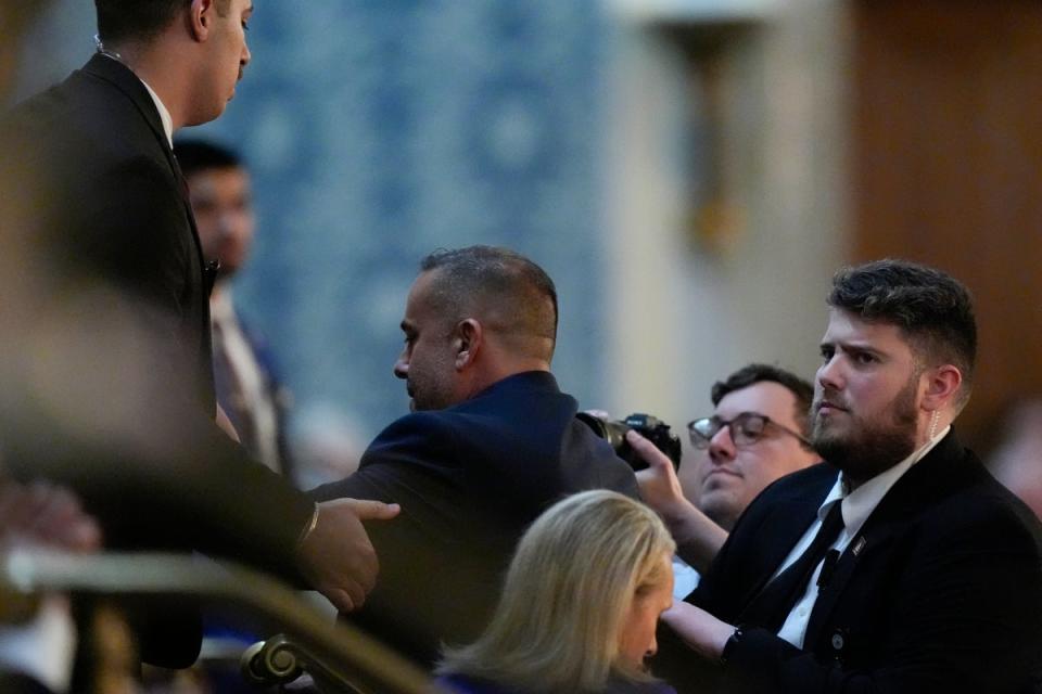 A protester is escorted out by security (AP)