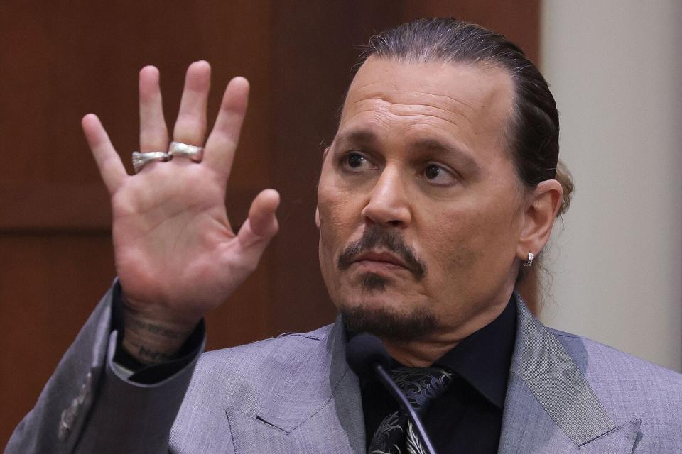 Actor Johnny Depp displays the middle finger of his hand, injured while he and his ex-wife Amber Heard were in Australia in 2015, as he testifies during his defamation trial against Heard at the Fairfax County Circuit Courthouse in Fairfax, Virginia, April 20, 2022. - Depp is suing ex-wife Heard for libel after she wrote an op-ed piece in The Washington Post in 2018 referring to herself as a public figure representing domestic abuse.