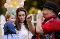 Britain's Catherine, Duchess of Cambridge, and Princess Charlotte watch a man inflate a balloon at a children's party at Government House in Victoria, British Columbia, Canada, September 29, 2016. REUTERS/Chris Wattie