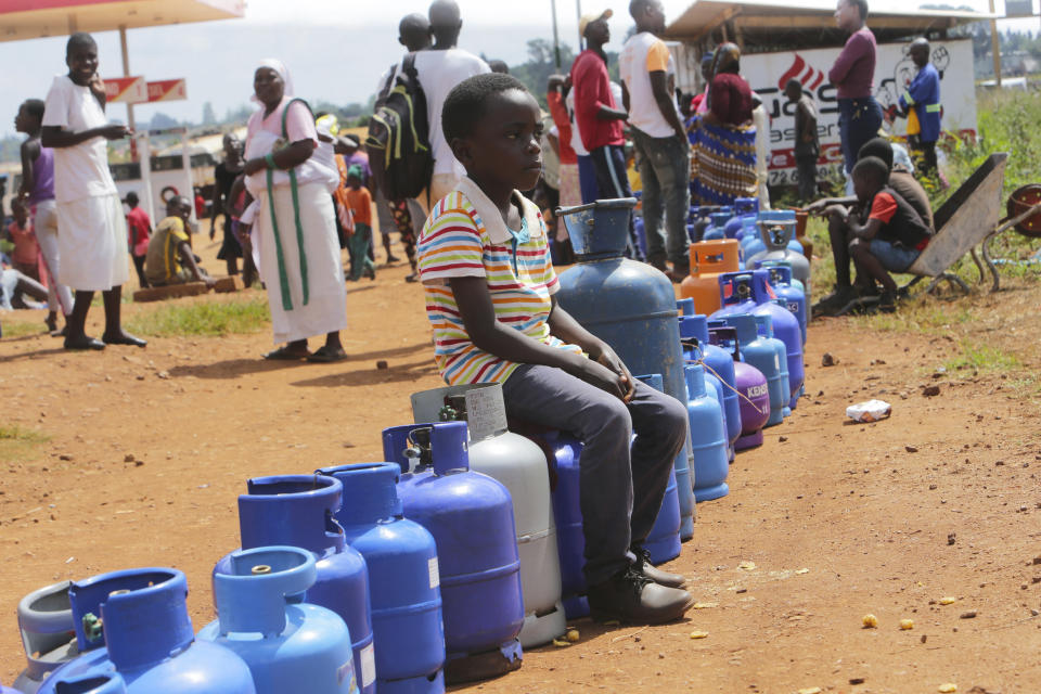 A young boy sits in a queue for cooking gas in Harare, Zimbabwe, Sunday, March, 29, 2020. Zimbabwean President Emmerson Mnangagwa announced a nationwide lockdown for 21 days, starting March 30, in an effort to stop the spread of the COVID-19 pandemic. The COVID-19 coronavirus causes less serious symptoms for most people, but for some, especially older adults and people with existing health problems, it can cause severe illness and even death. (AP Photo/Tsvangirayi Mukwazhi)