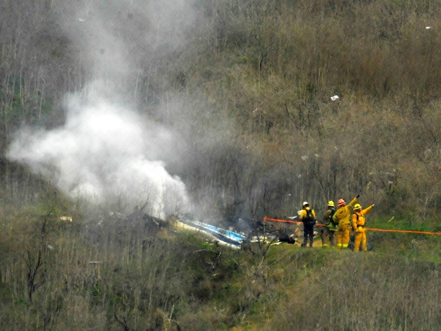 Firefighters work the scene of a helicopter crash where former NBA basketball star Kobe Bryant died in Calabasas, Calif., Jan. 26, 2020.