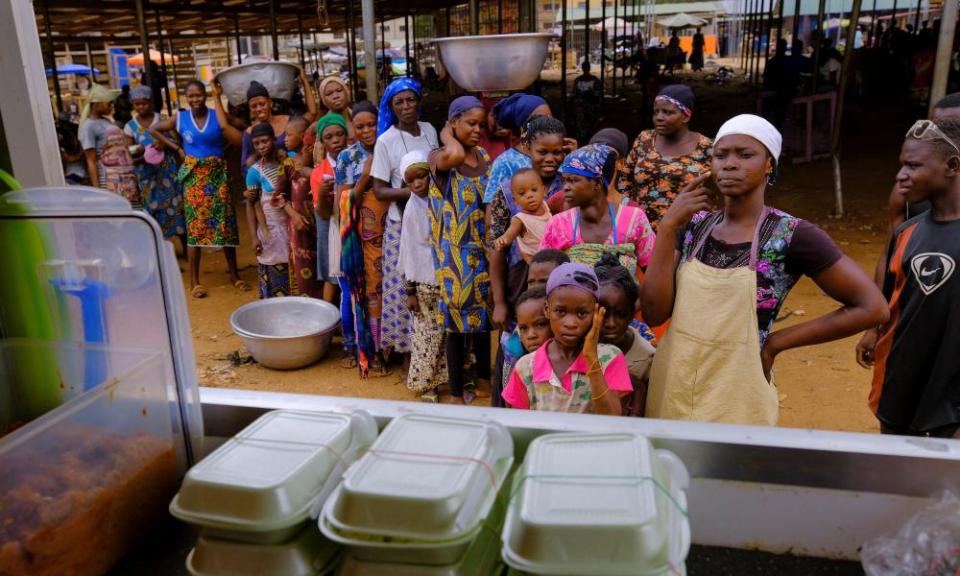 People line up to receive a free lunch from the Food For All Africa organisation in Accra on 3 June.