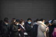 People wearing face masks to protect against the spread of the coronavirus line up for mass COVID-19 testing in a central district of Beijing, Friday, Jan. 22, 2021. Beijing has ordered fresh rounds of coronavirus testing for about 2 million people in the downtown area following new cases in the Chinese capital. (AP Photo/Mark Schiefelbein)