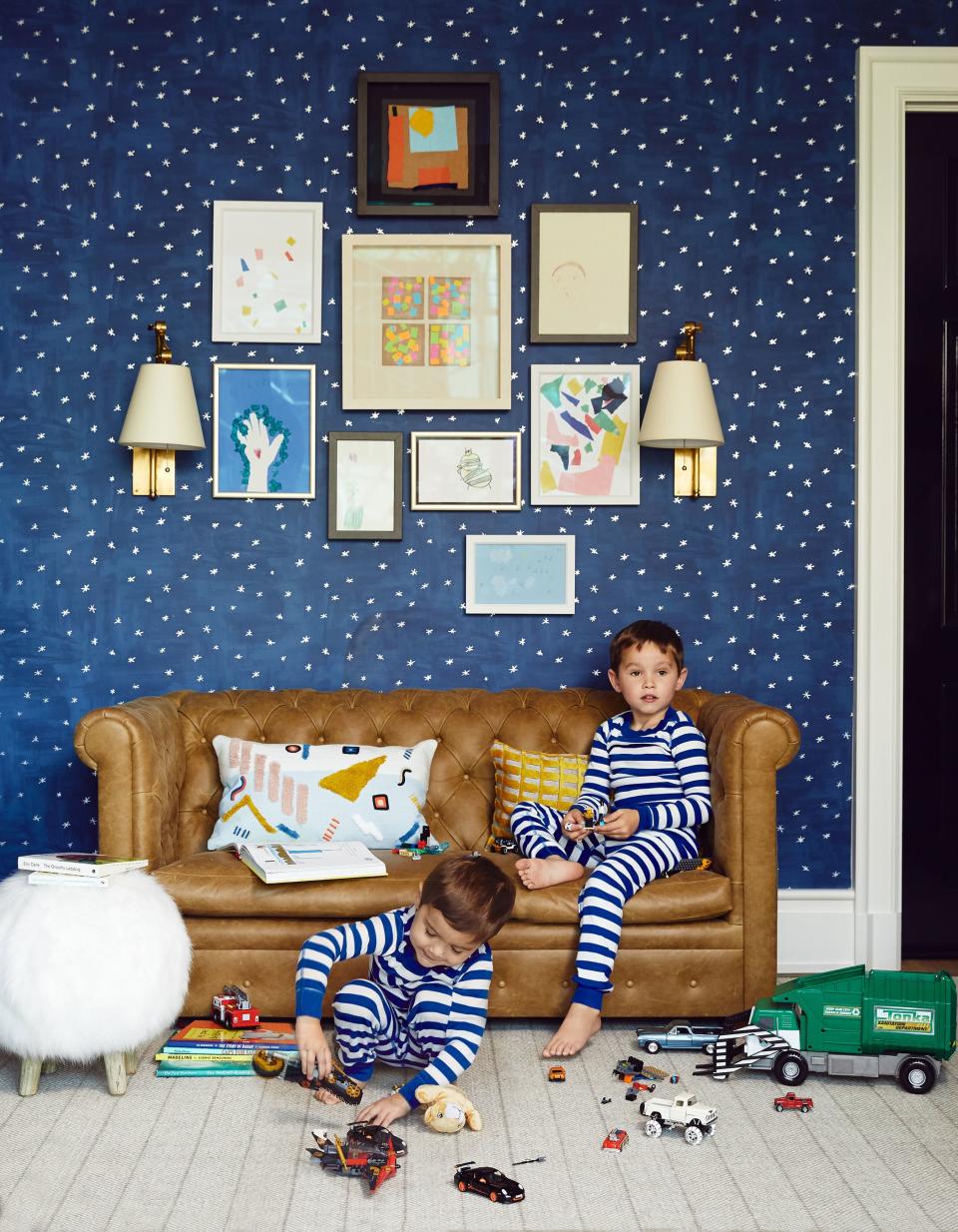 Kai and Knox play in their room. Knox’s own artwork hangs above the custom mini chesterfield sofa.