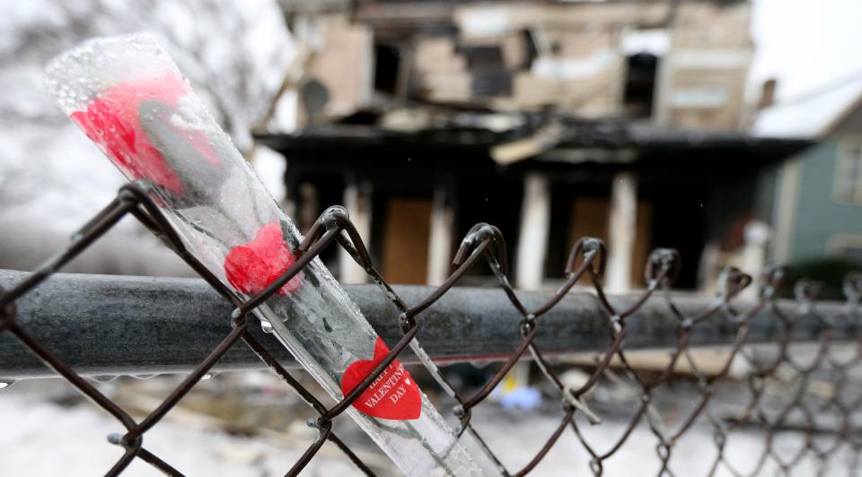 One of six Valentine’s Day roses is stuck in a fence Tuesday, Jan. 23, 2024, at the scene of Sunday’s house fire at 222 N. LaPorte Ave. where five children died in the blaze.